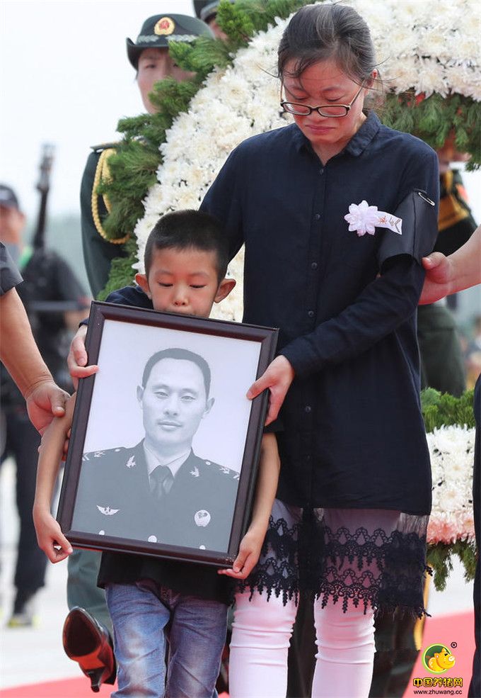 7月20日，杨树朋烈士的妻子邹丽娜、儿子杨一鸣在仪式上护送灵柩。