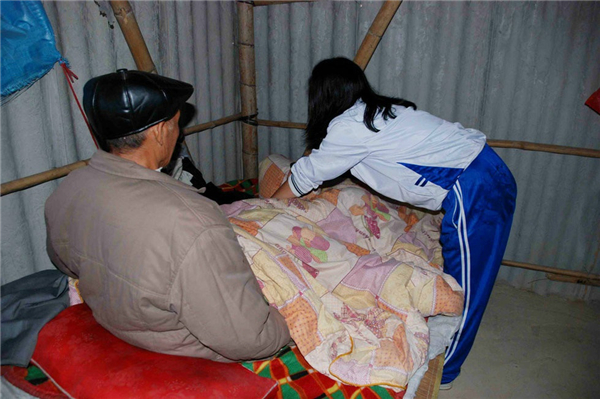 8、爷爷前两年得过脑中风，现在刚好腿脚还不是特别灵便，小梅白天照看电子游艺网站
，晚上则洗衣做饭照顾爷爷。图为吃饭的时候，小梅往爷爷碗里夹了一口菜。